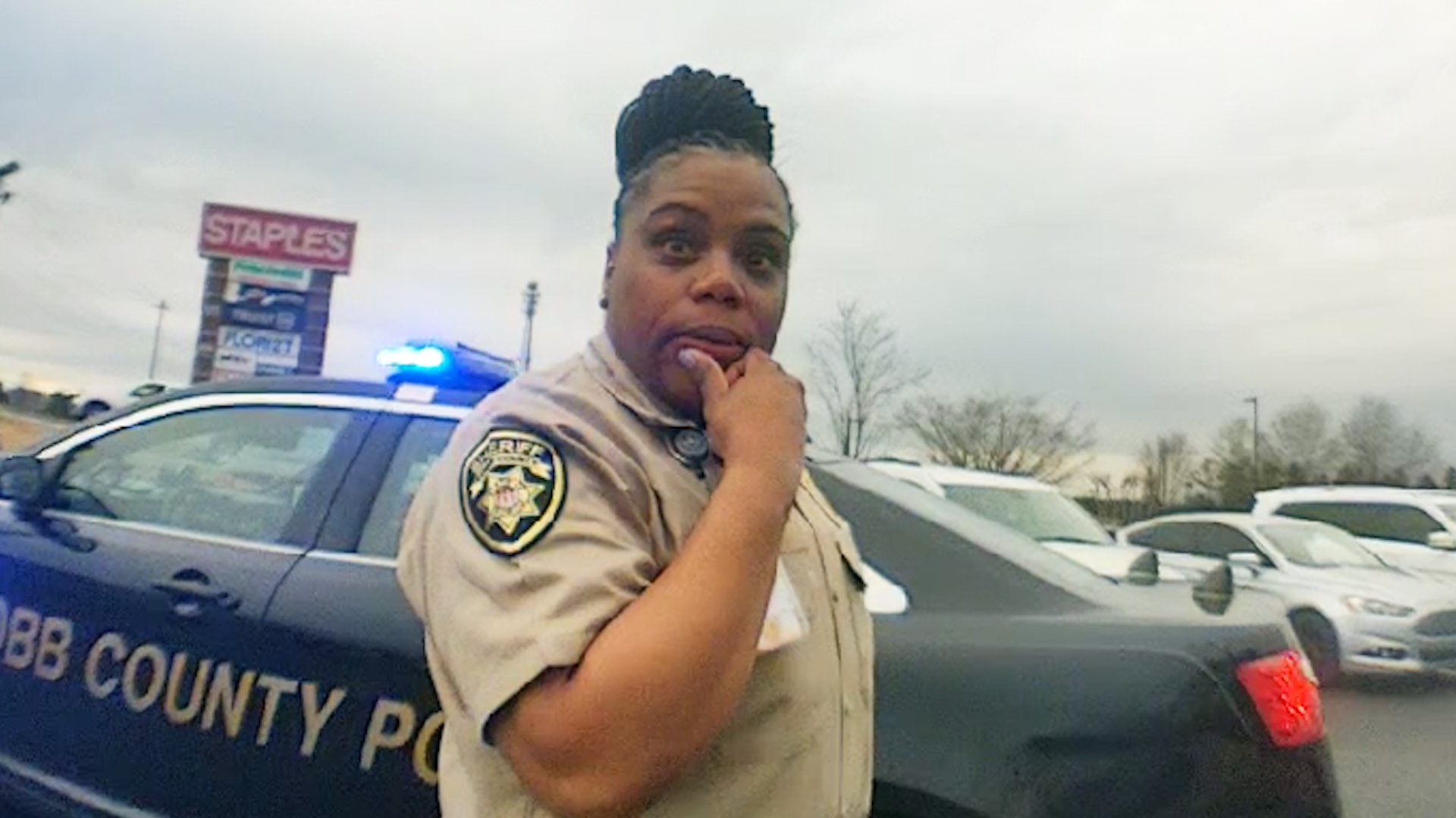 Body camera still 3: jailer near police vehicle
