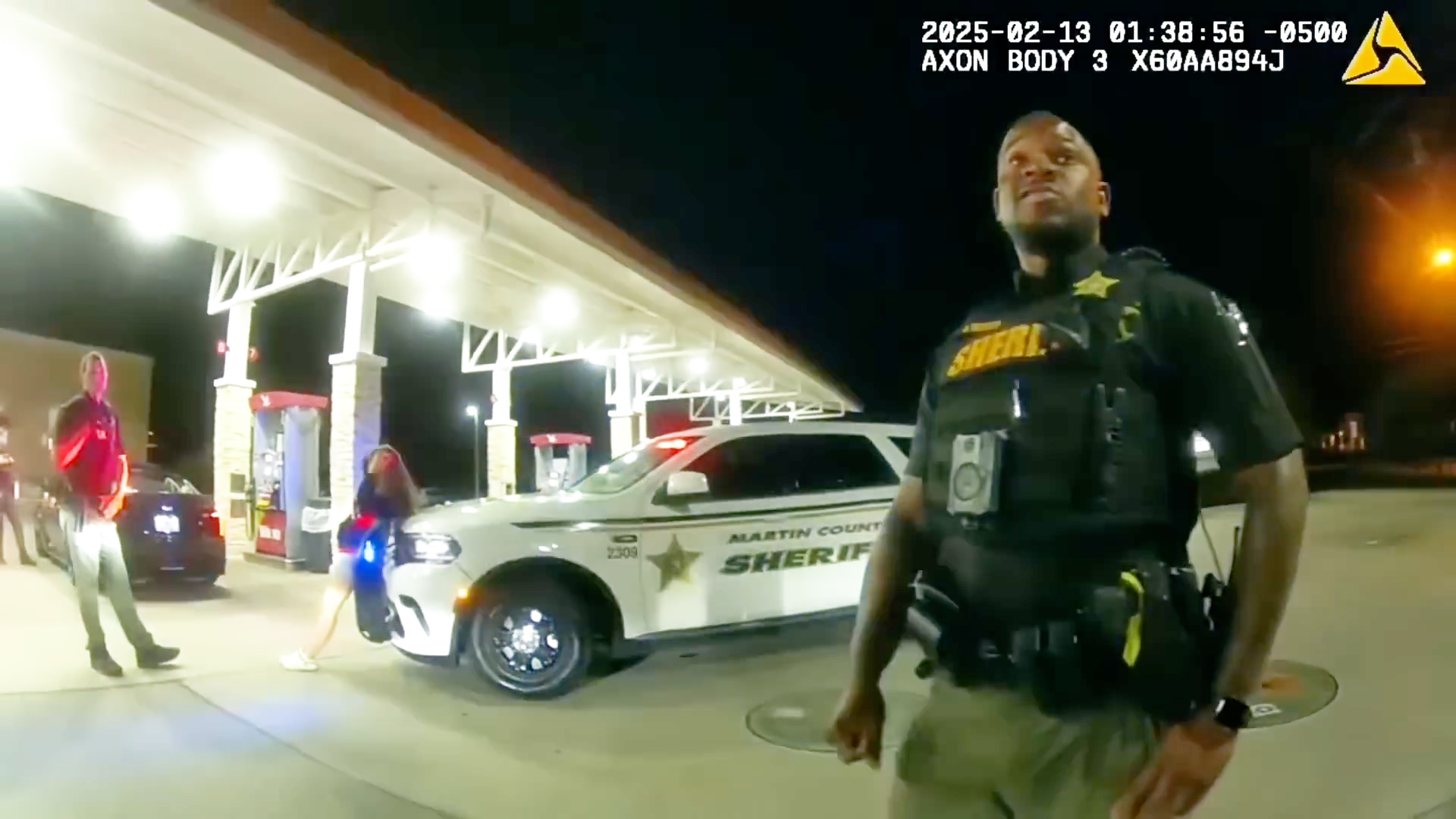 Martin County deputy Nicholas A. Thomas at the gas-station scene beside a marked sheriff's vehicle